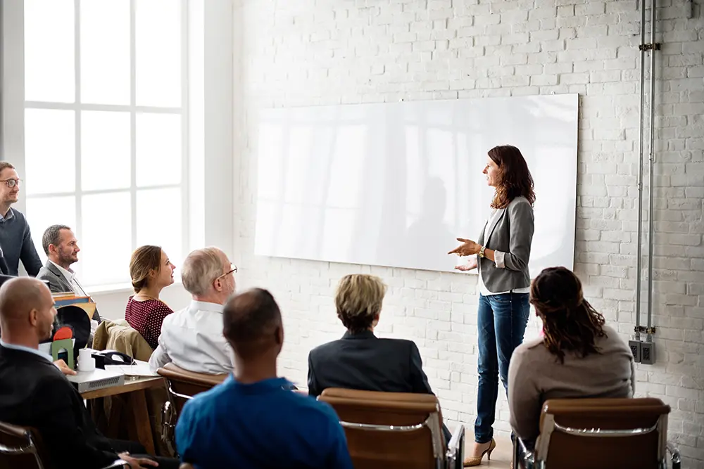 Woman presenting to group of coworkers