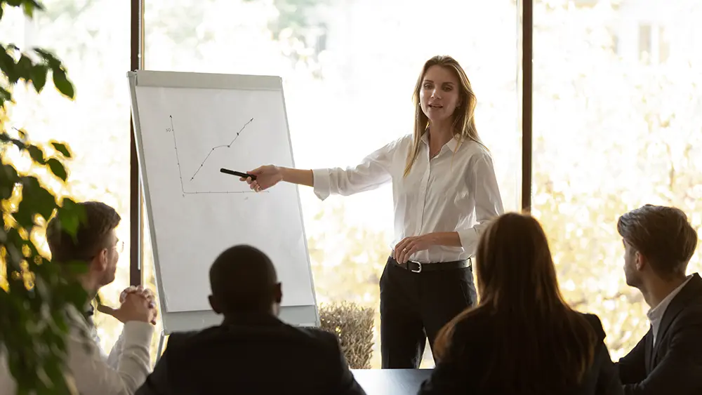 Woman presenting paper chart to group