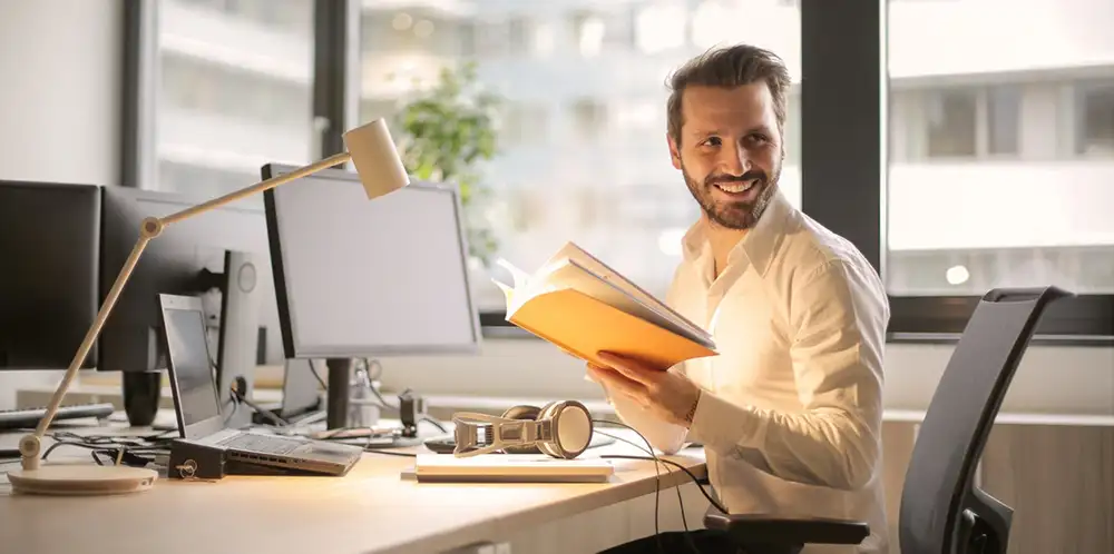 young business professional reading at his desk with desklamp