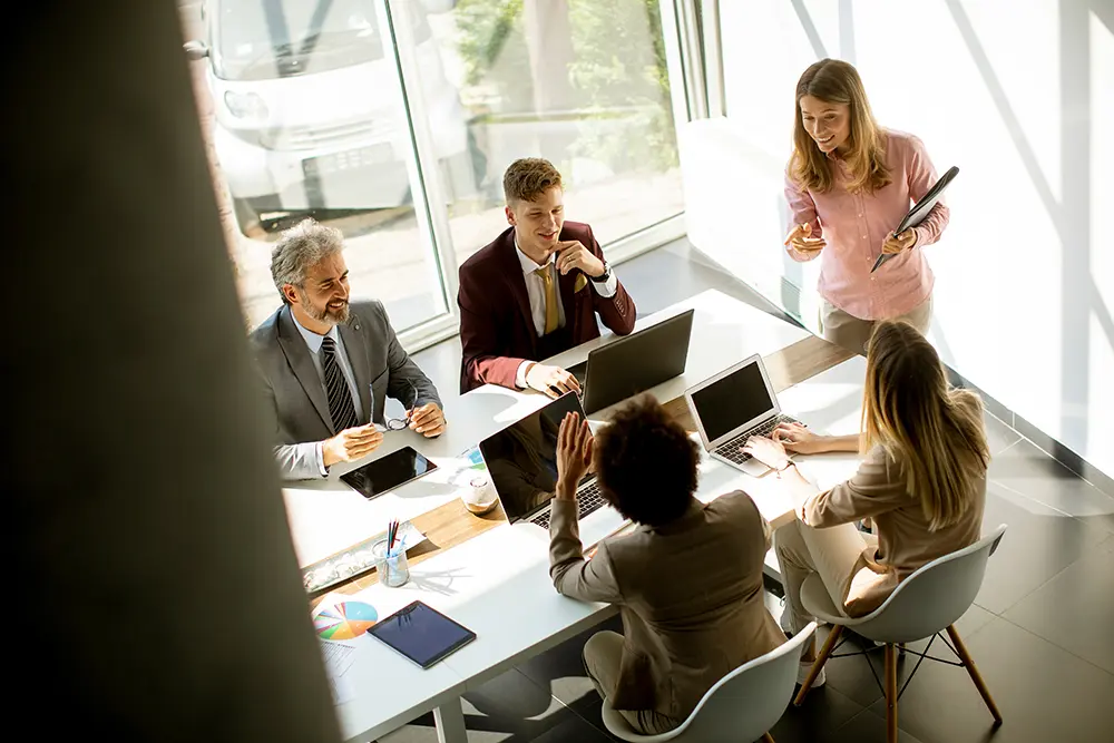 woman presenting to group of 5 coworkers