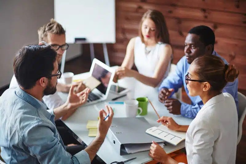 diverse group of employees meeting together around a conference room table