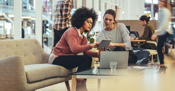 two women talking in office reception area