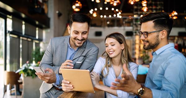 Three coworkers looking at tablet