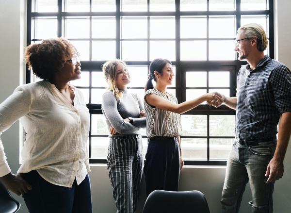 people at work greeting each other and shaking hands