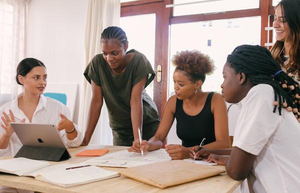 diverse group of employees with laptops working together at a conference table