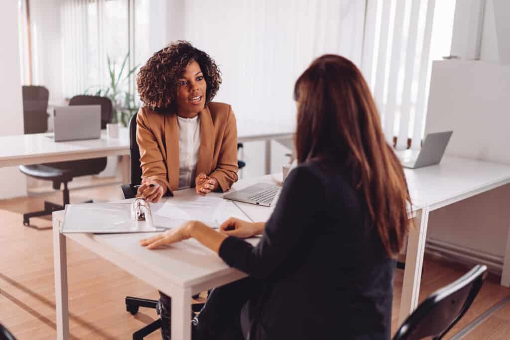 female black manager coaching an employee in the manager's office