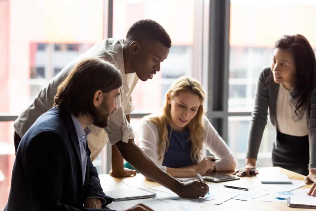 Concentrated mixed race diverse colleagues developing marketing strategy in office.