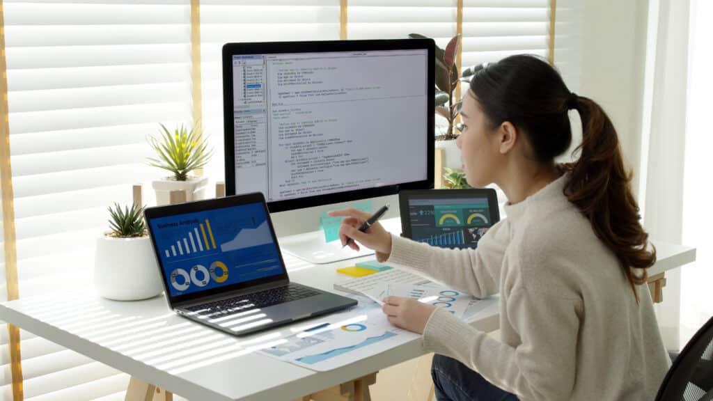 Asia young business woman sits at busy at home office desk