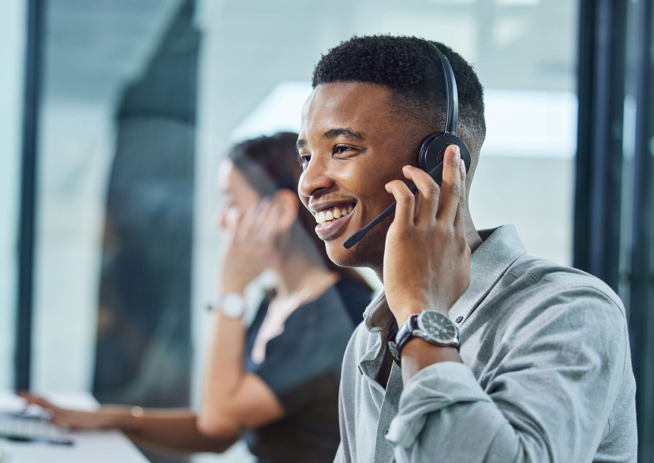 Im here to help you. Shot of a young call centre agent on a call in an office.