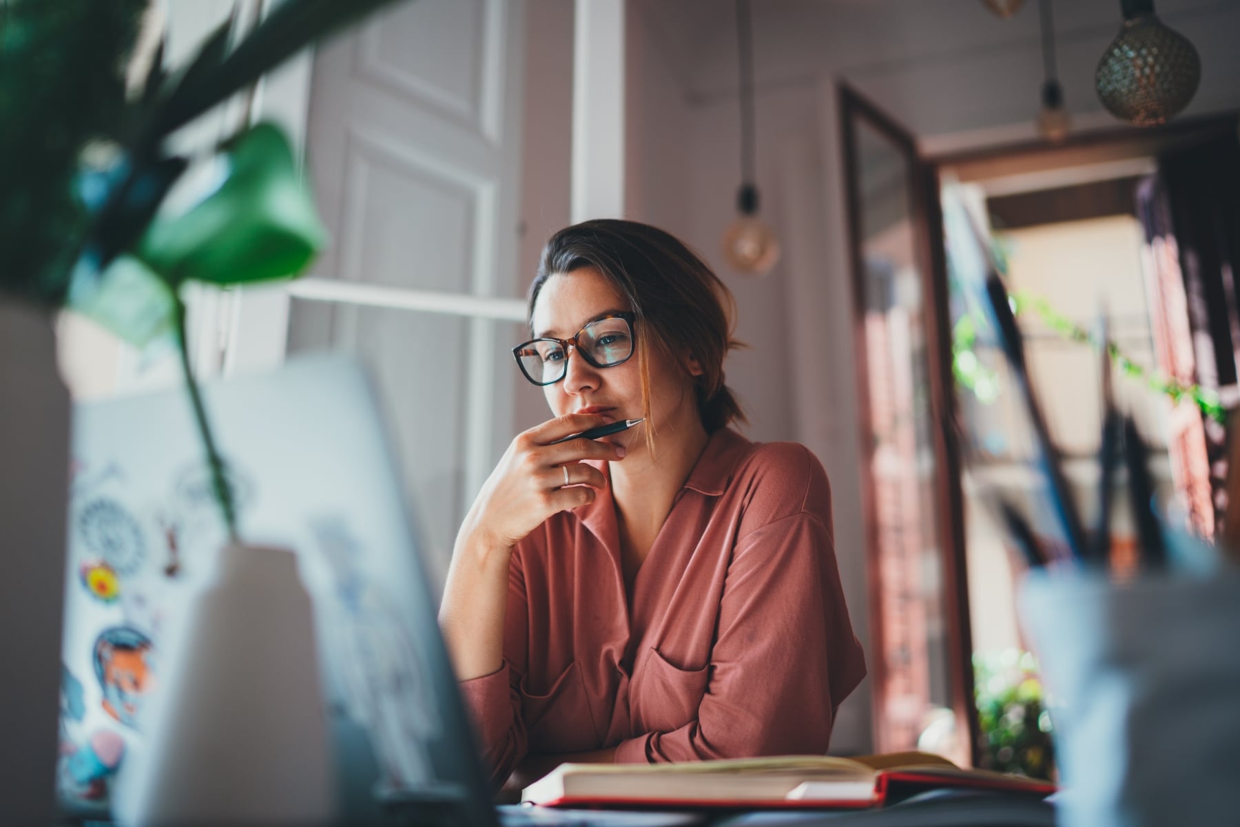 Woman thinking deeply while working on a laptop