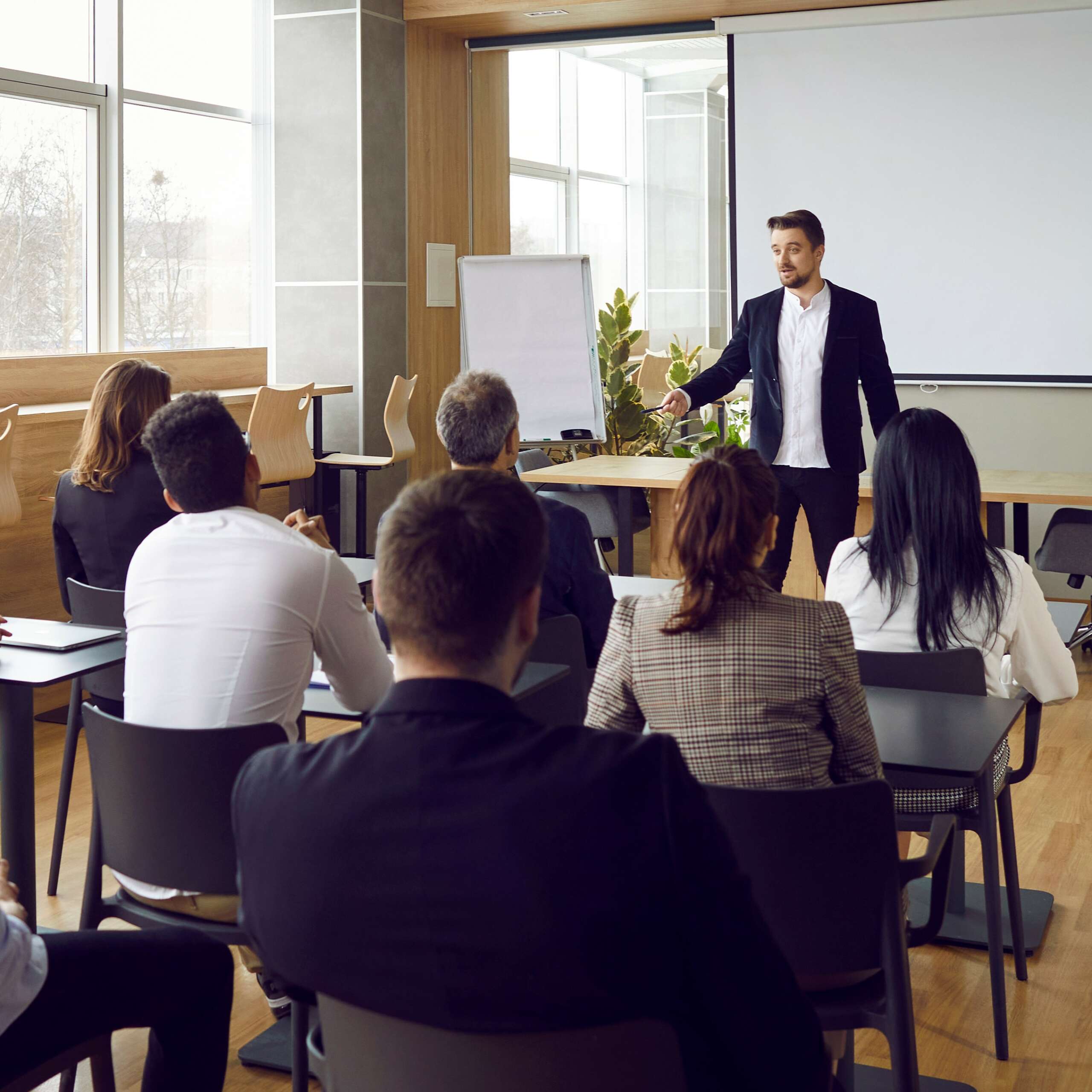 Business Training Event Team of people sitting at desks in office and having class with business teacher
